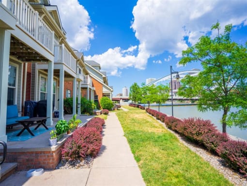 View from sidewalk in front of private apartment porches and balconies towards downtown Rochester and the "Freddie Sue" arched bridge over the Genesee River