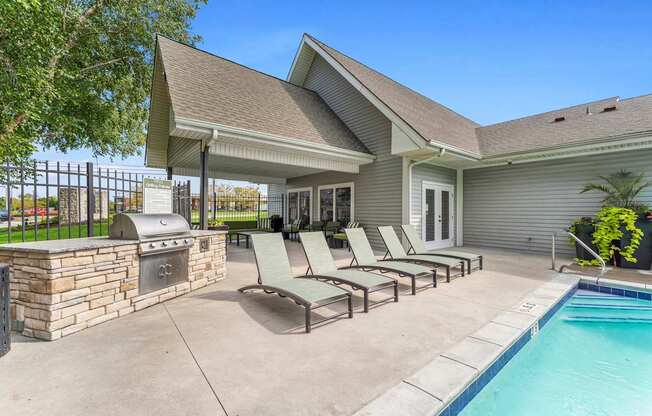 A house with a pool and lounge chairs.