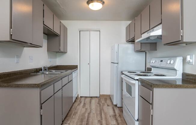 Sedona | One Bedroom Kitchen with plank style flooring and white appliances