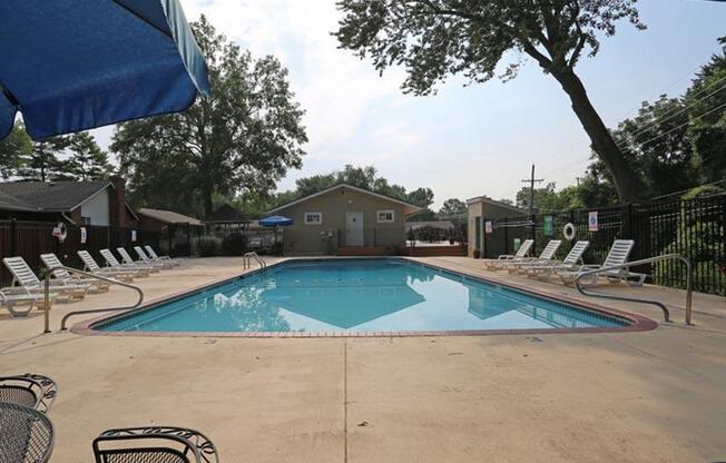 a swimming pool with chairs and umbrellas around it