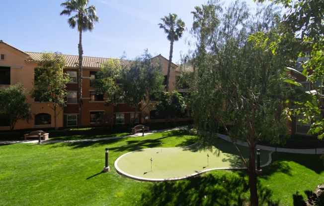 A green lawn with a putting green in the middle of it.