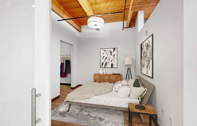 A bedroom with a bed, a bench, and pictures on the wall.