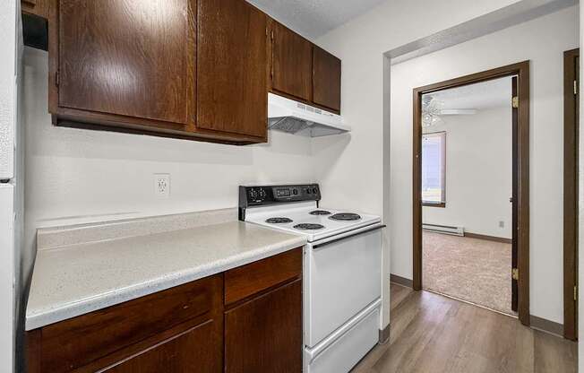 A kitchen with white appliances and wooden cabinets.