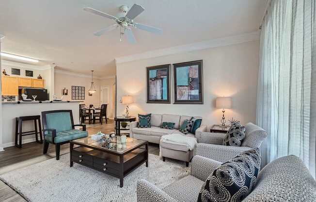 A living room with a white ceiling fan and a grey couch.