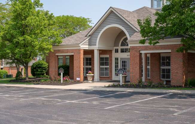 the front of a building with a driveway and a parking lot