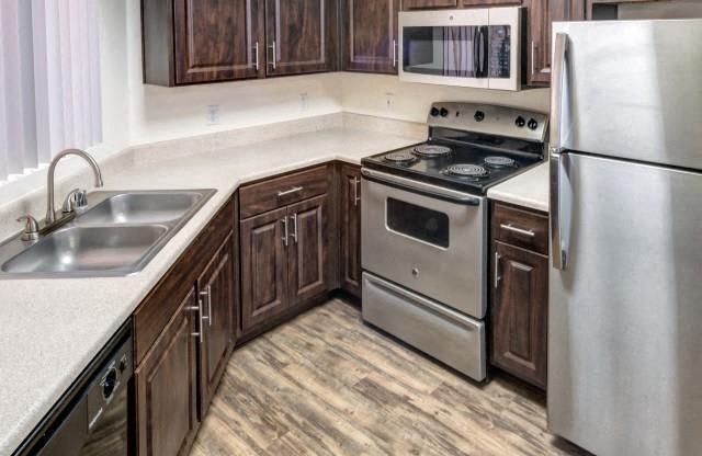 Ingleside Apartments kitchen with dark brown cabinets, white counter tops and stainless steel appliances