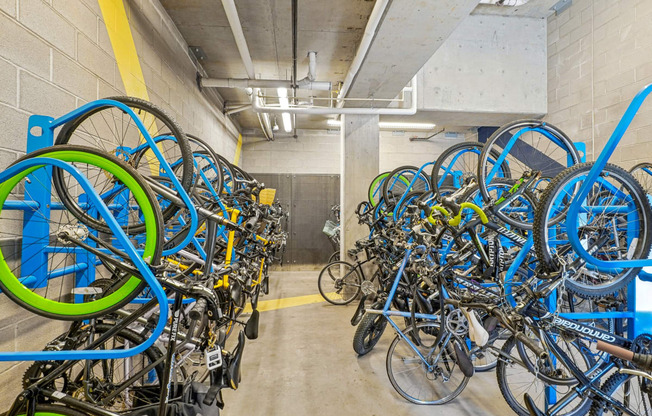 a room filled with lots of blue and green bikes