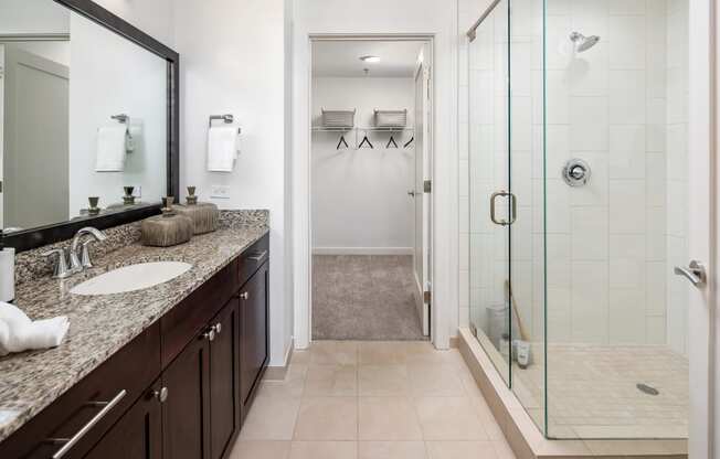 a bathroom with a shower and a sink and a mirror