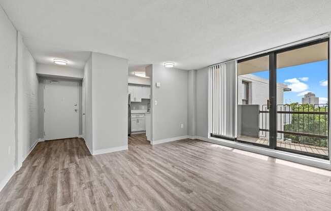 an empty living room with a large window and a balcony