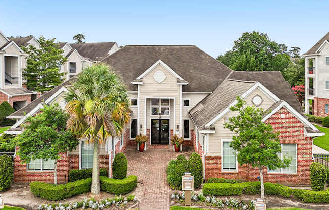 A house with a brick front yard and a palm tree.