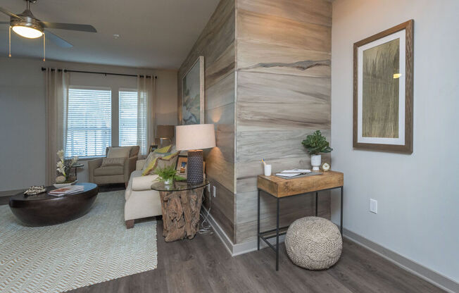 A living room with a wooden accent wall and a ceiling fan.