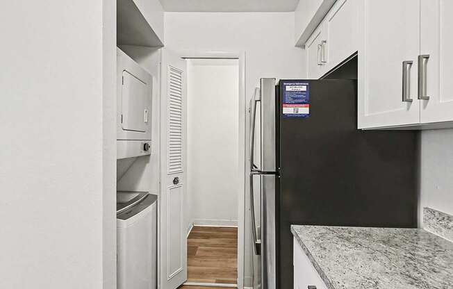 A kitchen with a washer and dryer and a pantry at Trappers Cove Apartments, Lansing