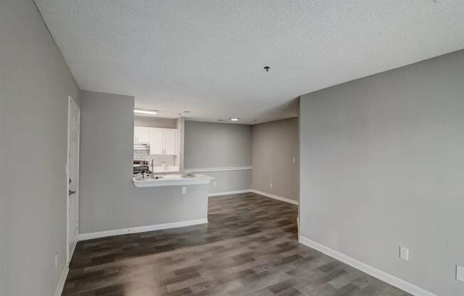 an empty living room and kitchen with a hard wood floor at The Sapphire, Decatur