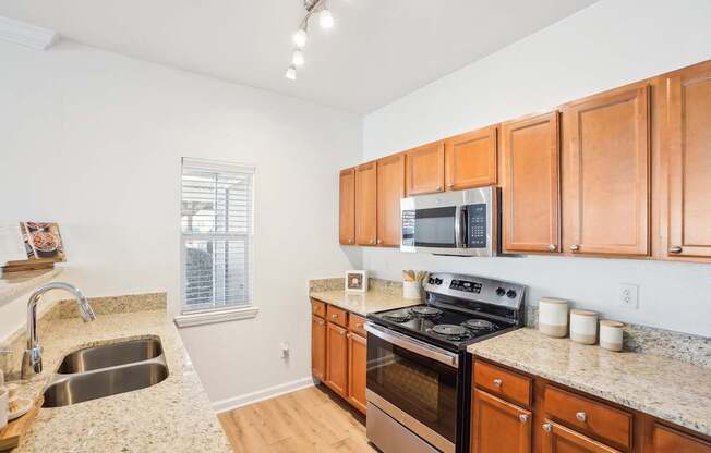 A kitchen with wooden cabinets and a granite countertop.