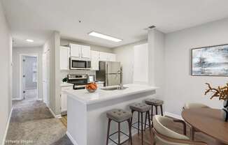 A kitchen with a white counter and bar stools.