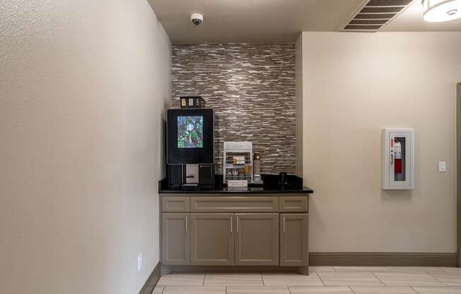 A wall with a stone pattern separates a kitchen from a hallway.