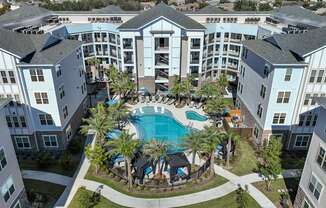 A large apartment complex with a pool in the middle.