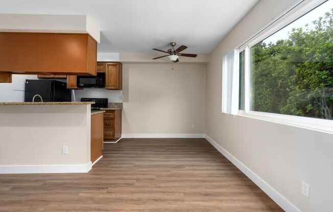 an empty room with a large window and a ceiling fan