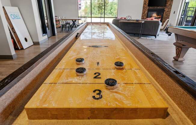 a shuffleboard table in the clubhouse of TRIO @ Southbridge apartments