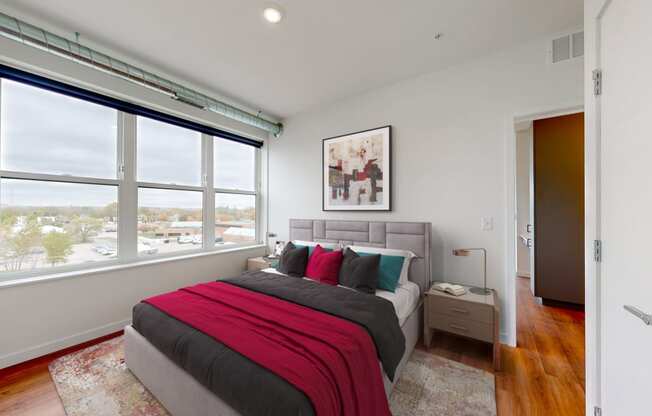 a bedroom with a bed and a large window