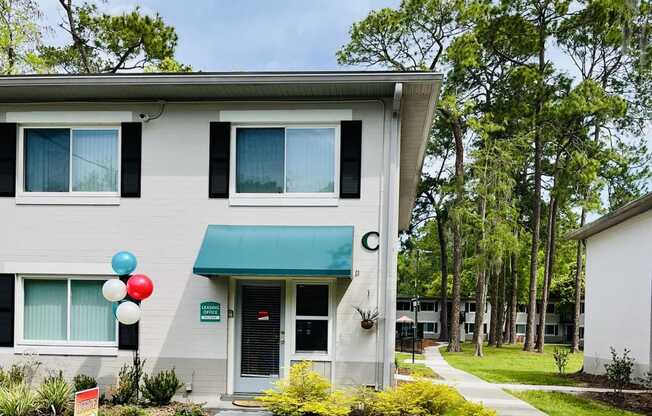 the front of a building with balloons outside of it