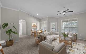 an open living room and dining room with couches and chairs and a ceiling fan