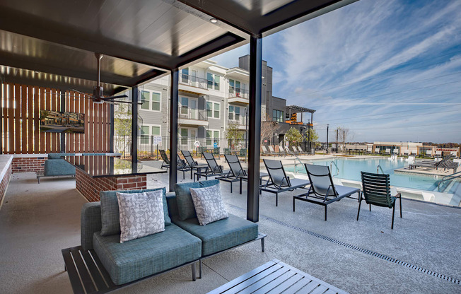 a living room with a couch and chairs next to a pool