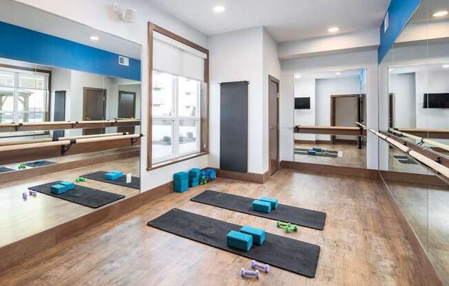 A yoga studio with mats and blocks on the floor.