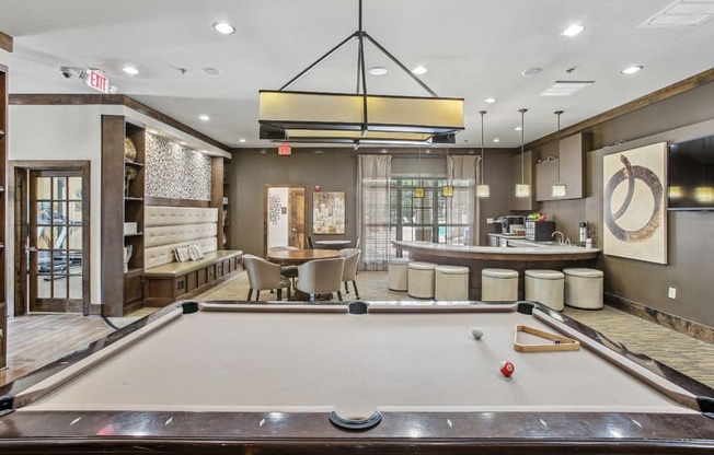 a pool table in the lobby of a club with a bar