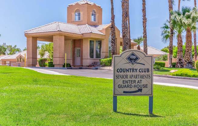 A sign in front of a building that says Country Club Senior Apartments Enter at Guard House.