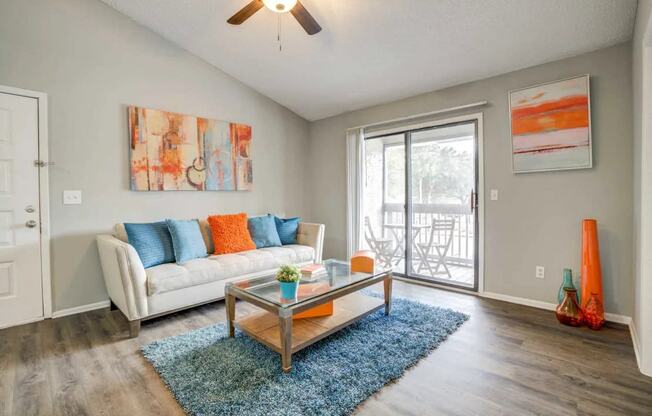a living room with a couch and a coffee table and a sliding glass door