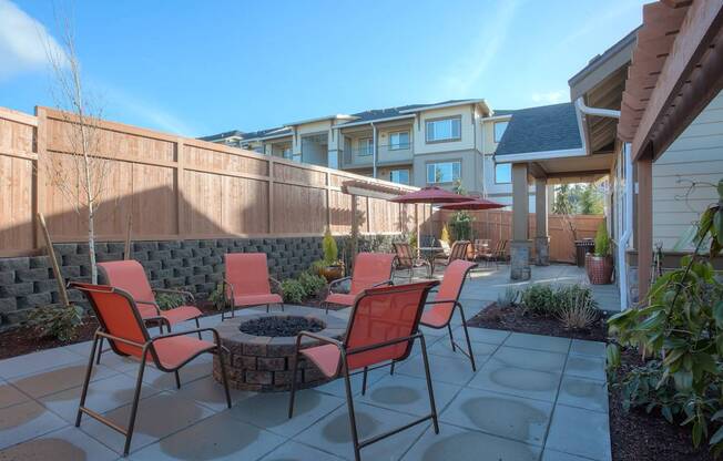 A patio with a table and chairs is surrounded by a wooden fence. at Mill Creek Meadows Apartments, Mill Creek, WA