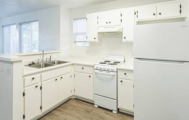 a white kitchen with white appliances and white cabinets