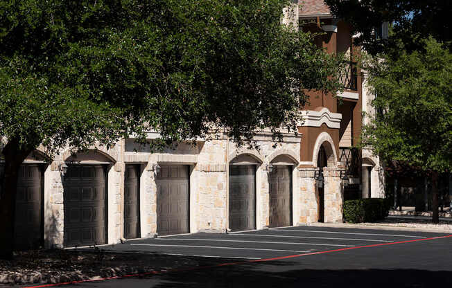 A building with arched doorways and a parking lot in front.