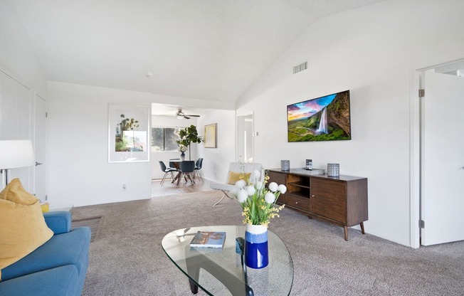 a living room with a blue couch and a glass coffee table