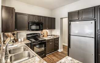 a kitchen with black cabinets and stainless steel appliances