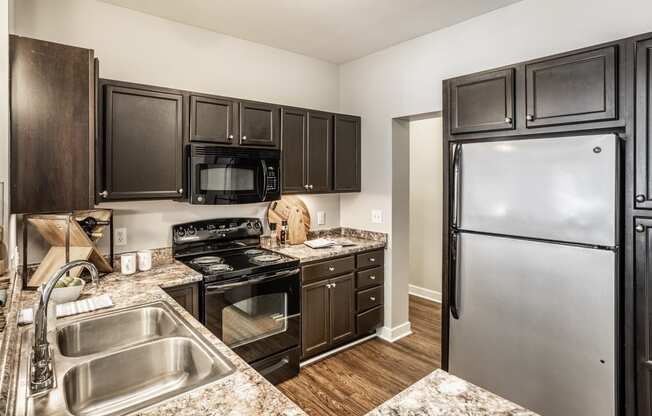 a kitchen with black cabinets and stainless steel appliances