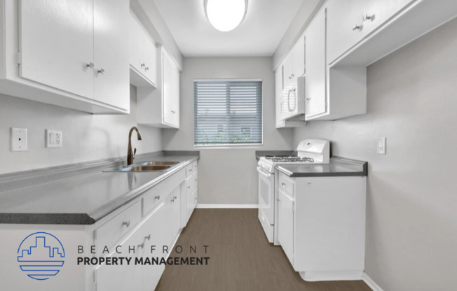 a kitchen with white cabinets and white appliances and a window