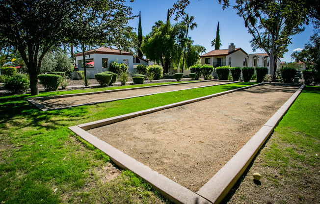 a yard with a path and houses in the background