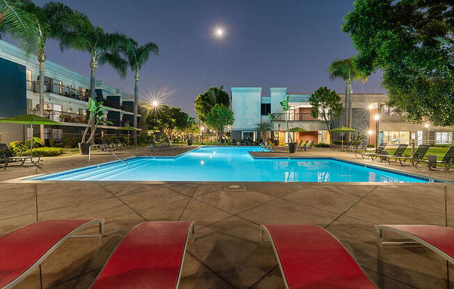 Community Swimming Pool with Pool Furniture at Madison Park Apartments located in Anaheim, CA.