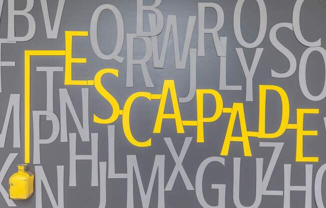 a wall filled with letters and a yellow vase