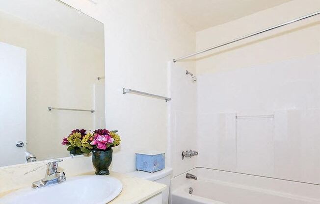 a white bathroom with a sink and a mirror and a shower at Villa La Paz Apartments, California, 90706