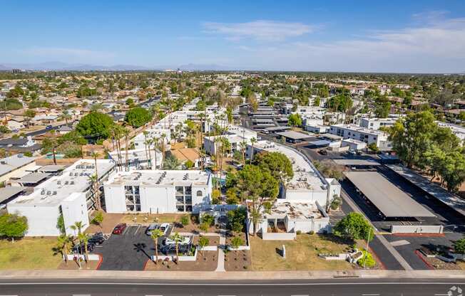 an aerial view of a city with white buildings and trees