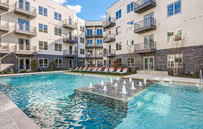 Sparkling resort style swimming pool with cushioned lounge chairs