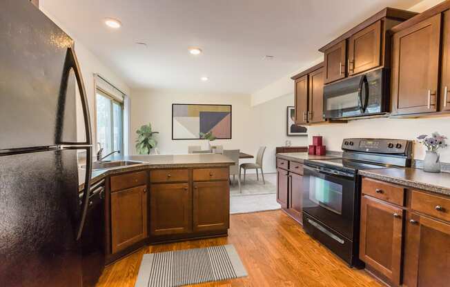 a kitchen with dark wood cabinets and stainless steel appliances