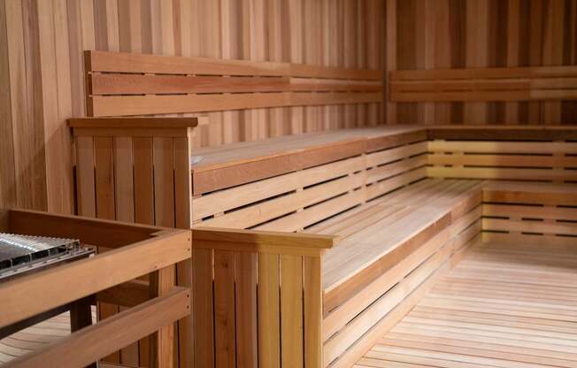 A wooden sauna with benches and a heater.