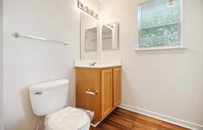 A white toilet sits next to a wooden cabinet in a bathroom.
