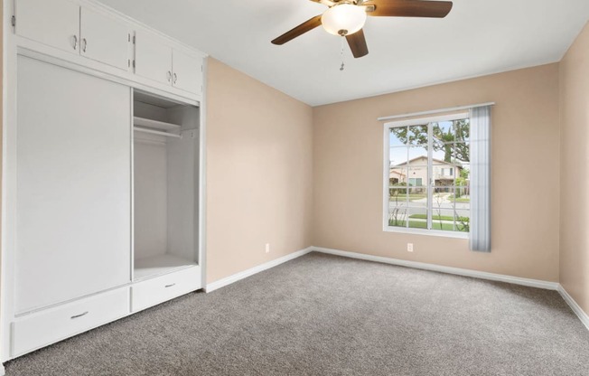 One Bedroom Apartments with Van Nuys, CA - Colonial Manor Spacious Bedroom with Carpet Flooring, Large Closet, and Ceiling Fan