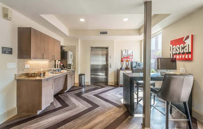 A stylish resident coffee bar here at Lakewood on the Trail with wood cabinets, granite countertops, mosaic backsplash, espresso machines, and bar seating, creating a convenient and inviting refreshment area.