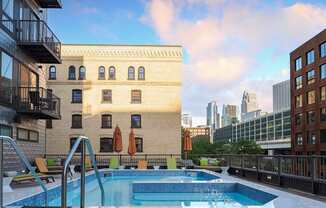 A swimming pool on a balcony with a view of the city.
